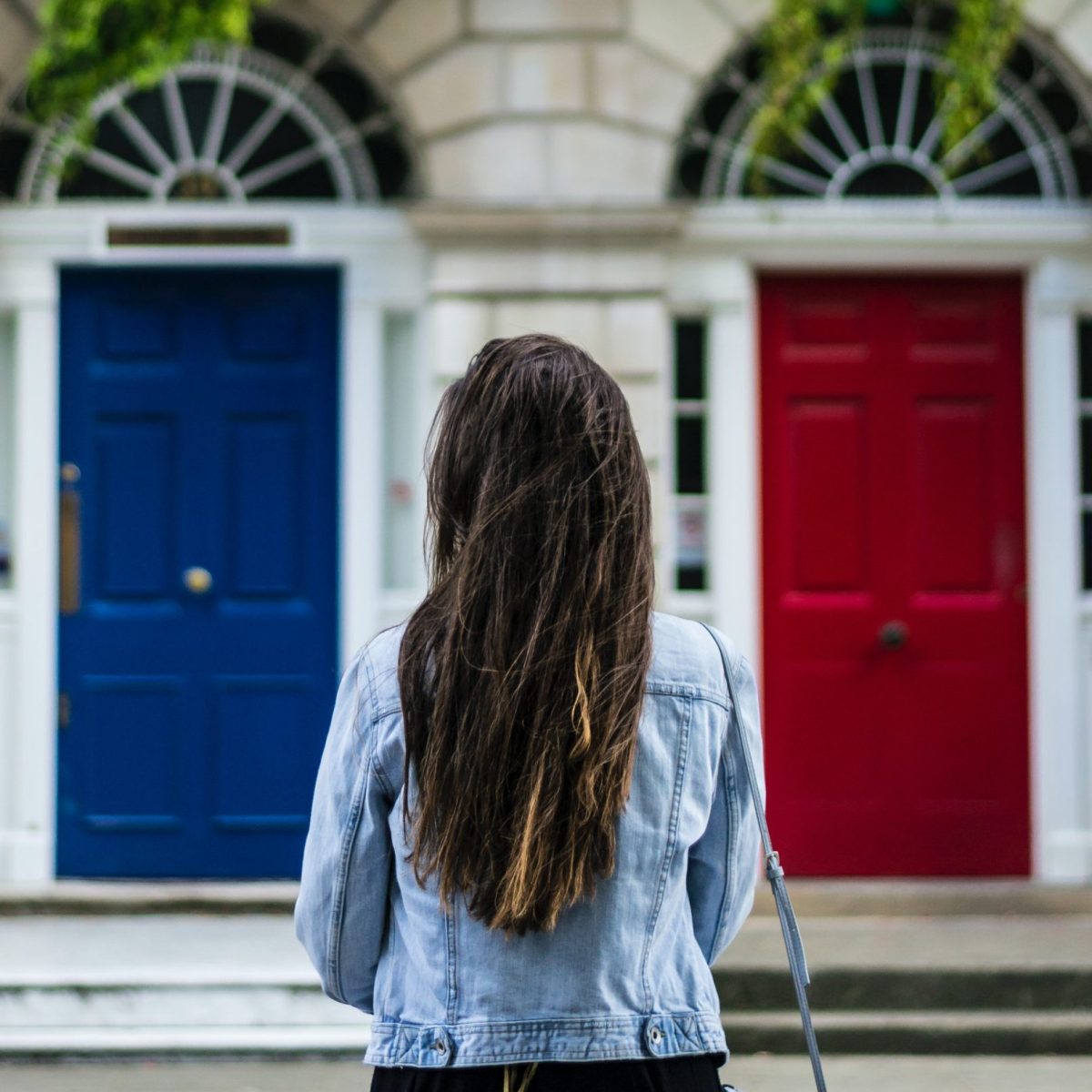 Woman choosing between red and blue door